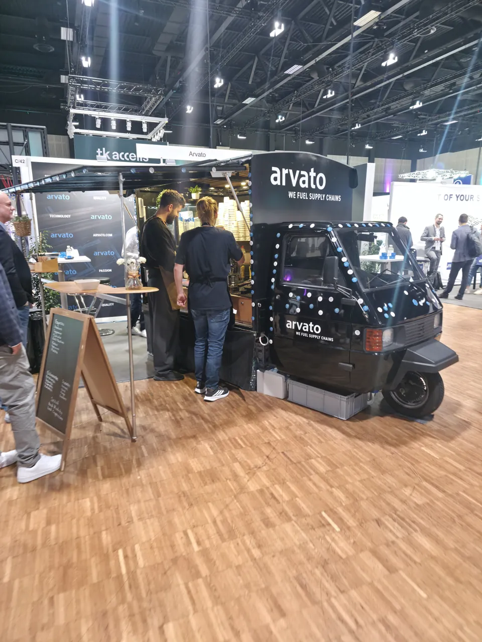 Piaggio Ape mit Event-Branding und Barista-Team am Messestand